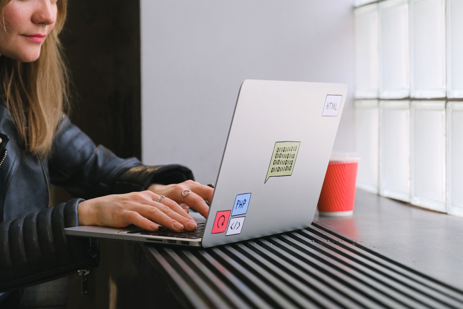 Freelance al lavoro con il portatile mentre decide come aumentare i prezzi senza perdere clienti