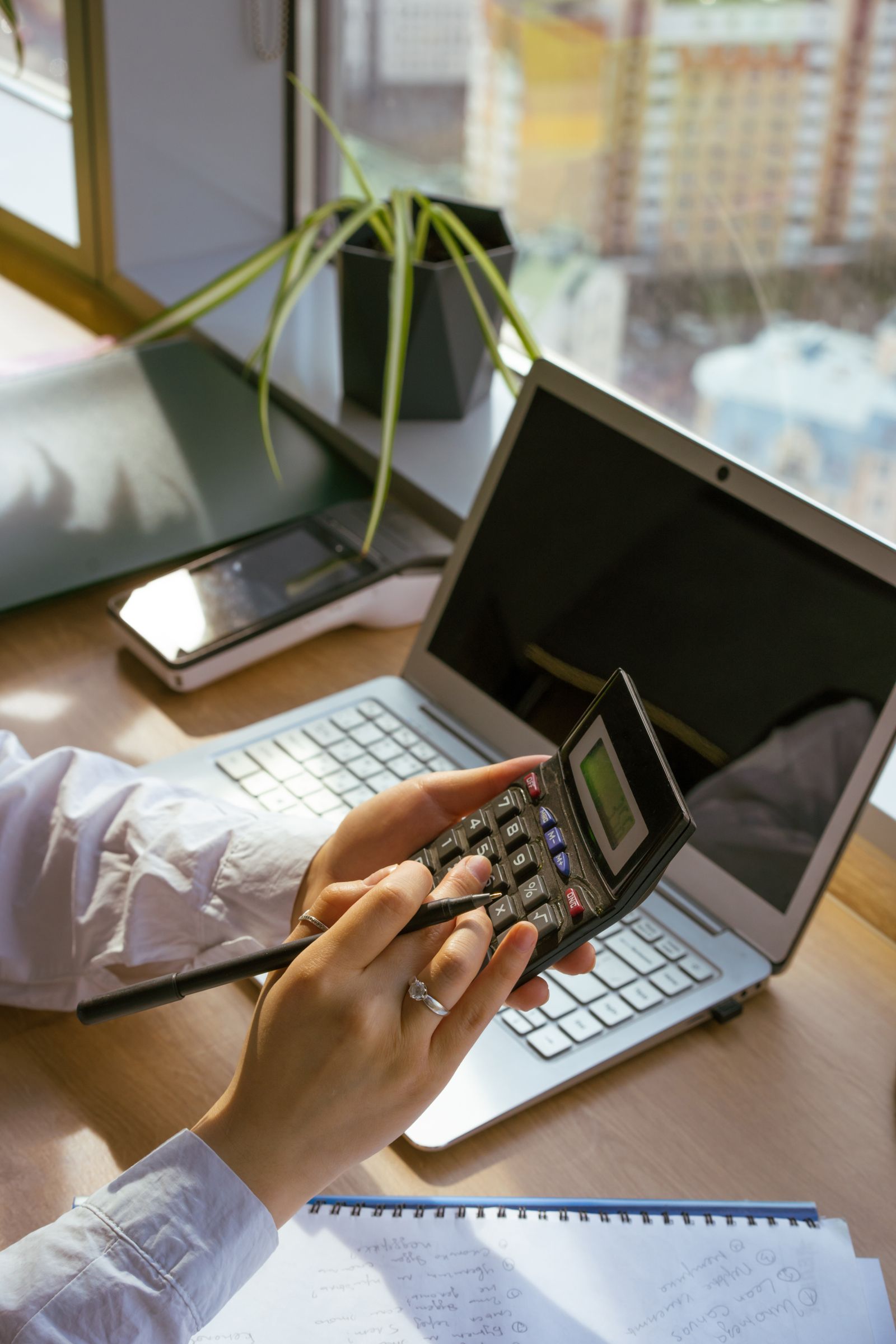 business model canvas freelance: calcolatrice e laptop per contare le spese