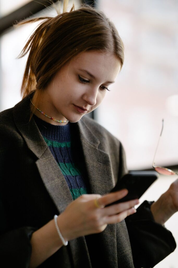 Donna con lo smartphone in mano che valuta le chiamate a freddo
