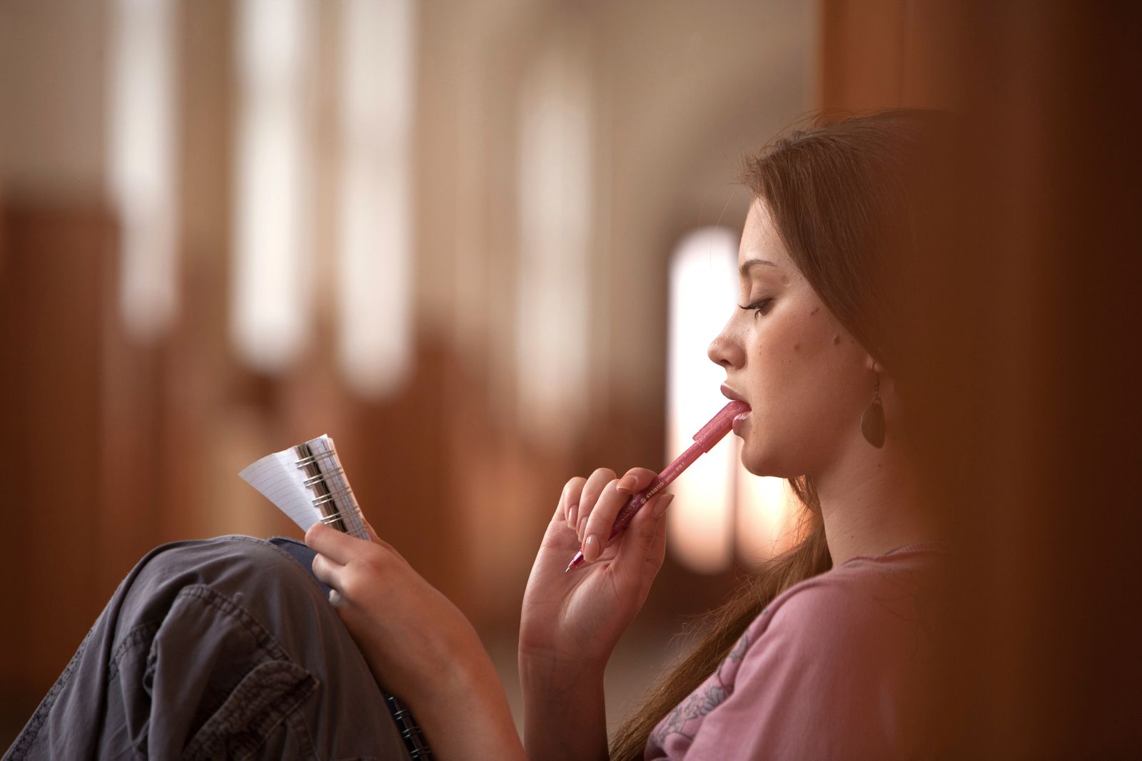 Giovane donna con quaderno e penna che riflette sulla differenza tra autonomo e freelance